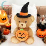 Boszorkány sapkás Halloweeni plüss maci tök figurával a kanapén (Keel Toys)
